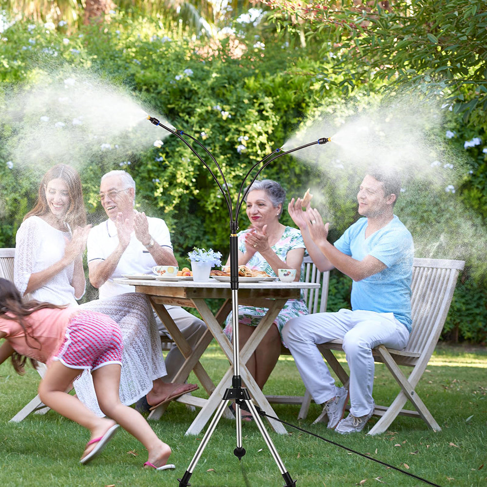 Family sitting outdoors at a table with a microphone stand and misting device.