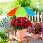 Colorful umbrella over a potted plant on a wooden deck with garden background