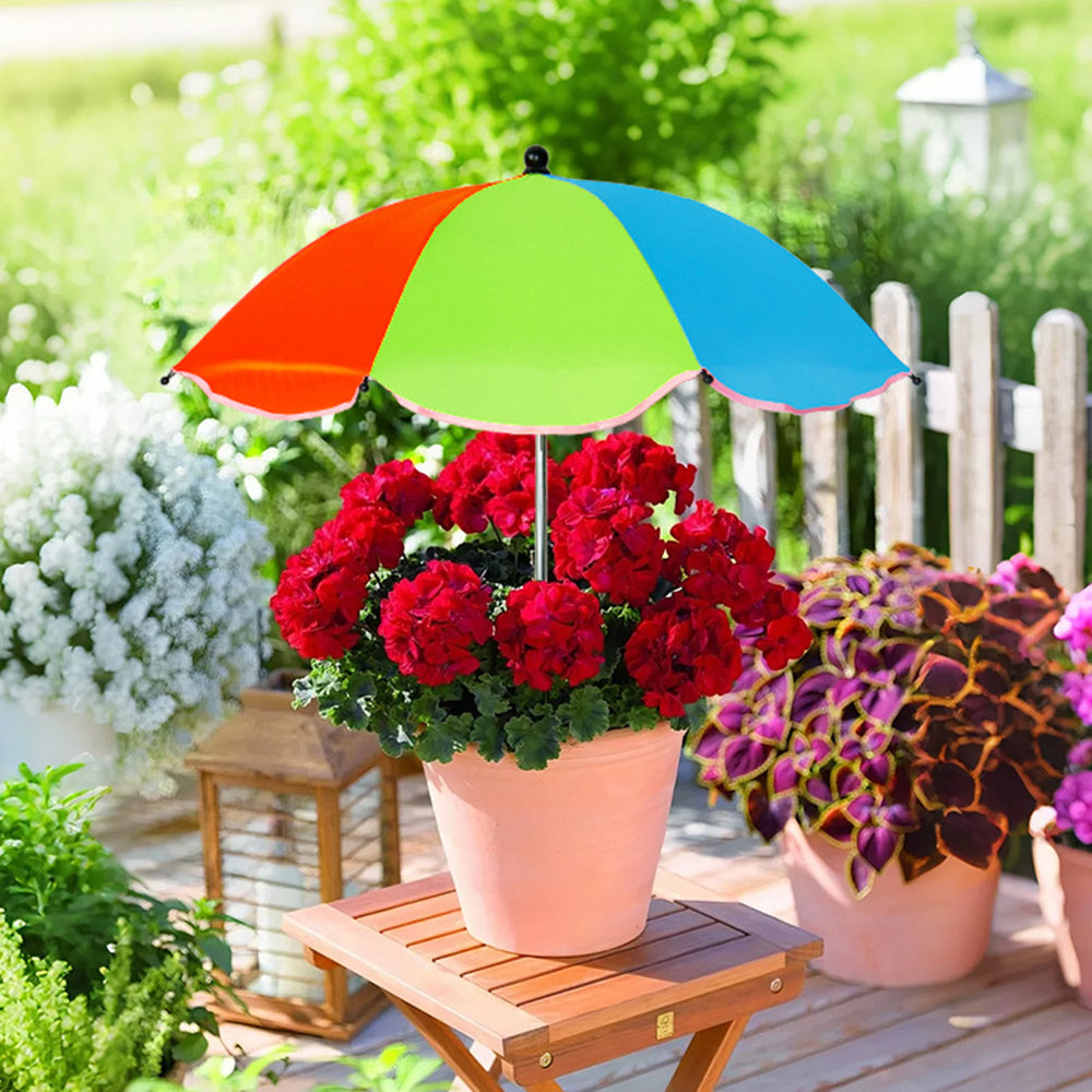 Colorful umbrella over a potted plant on a wooden deck with garden background