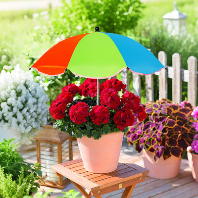 Colorful umbrella over a potted plant on a wooden deck with garden background