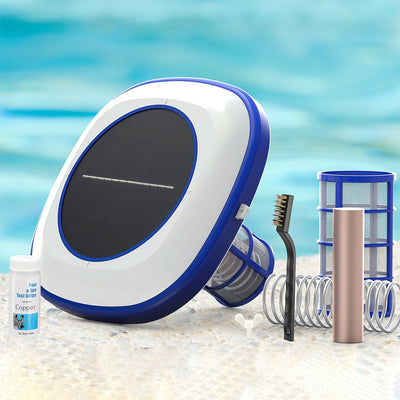 Solar panel, bottle, brush, and other items on a beach with ocean in the background